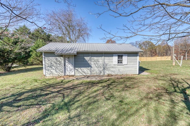 view of outbuilding with fence and an outbuilding