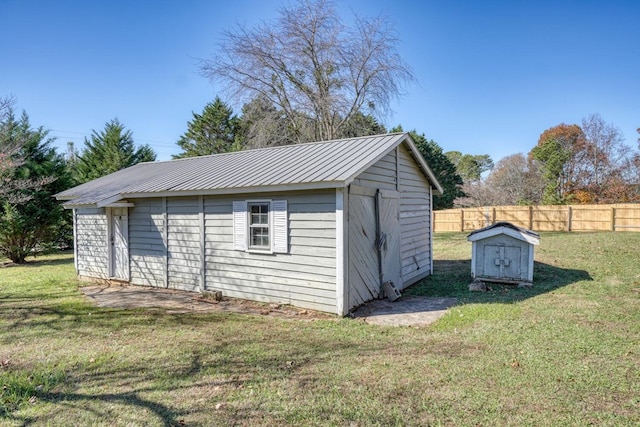 view of outdoor structure featuring fence and an outbuilding
