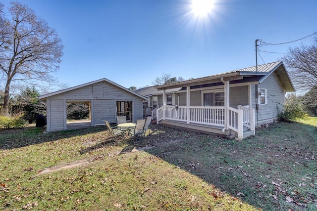 back of property with a yard, a porch, and metal roof