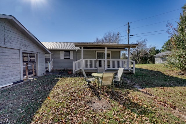 rear view of house with a yard and metal roof