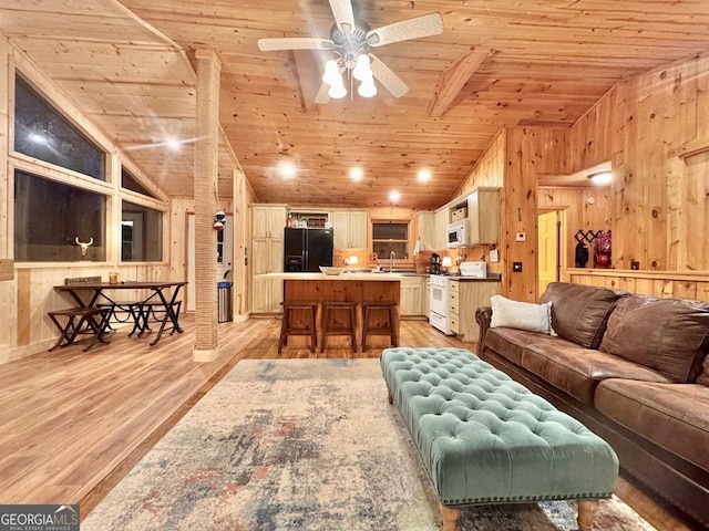 living room with ceiling fan, vaulted ceiling, wood ceiling, wood walls, and light wood-type flooring