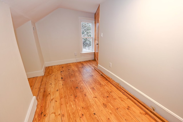 additional living space featuring light hardwood / wood-style floors and vaulted ceiling