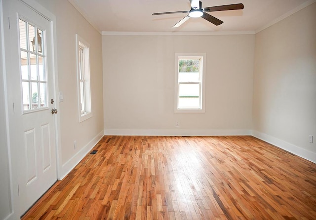 spare room featuring crown molding, light hardwood / wood-style floors, and a healthy amount of sunlight