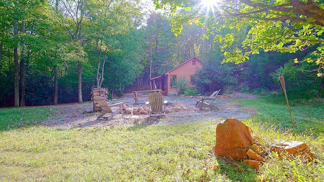 view of yard featuring a view of trees and a fire pit