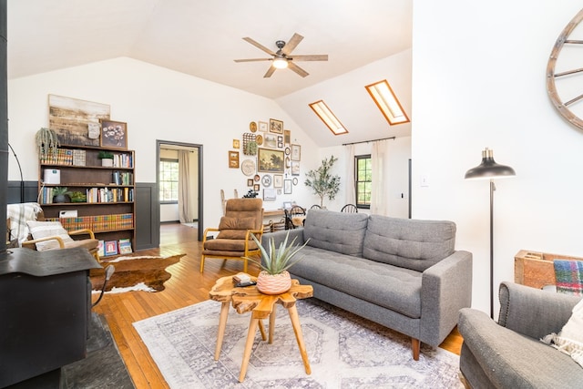 living area with wood-type flooring, a ceiling fan, and vaulted ceiling