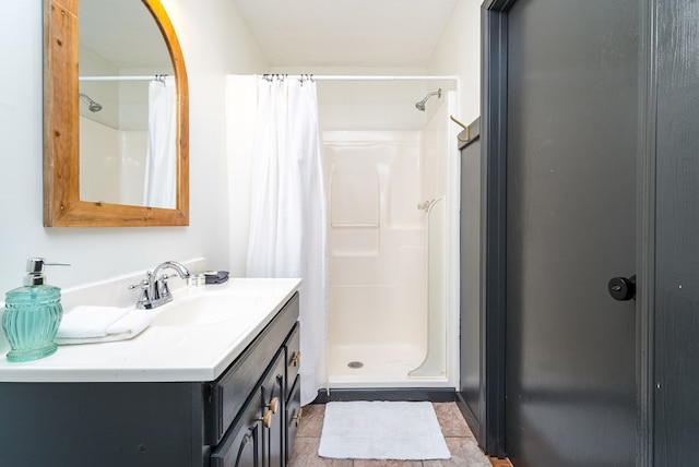 full bathroom with vanity, a stall shower, and tile patterned flooring