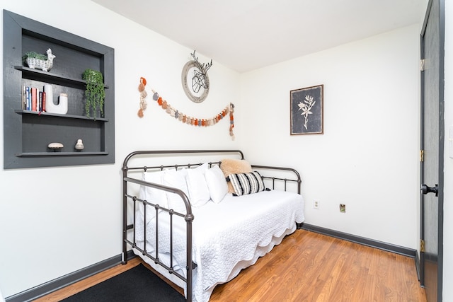 bedroom with baseboards and wood finished floors