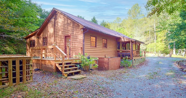 view of property exterior featuring metal roof and a wooden deck