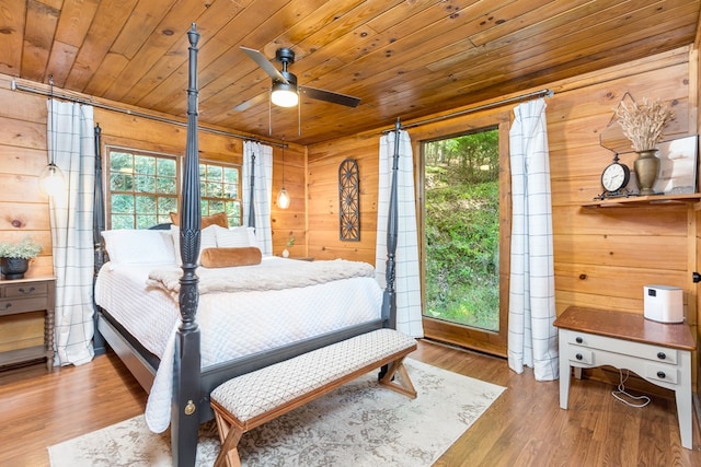 bedroom with wooden walls, wooden ceiling, and wood finished floors