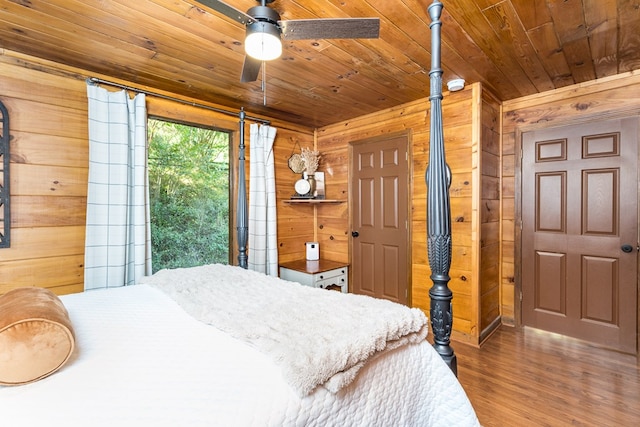 bedroom with wood finished floors, wood walls, and wooden ceiling