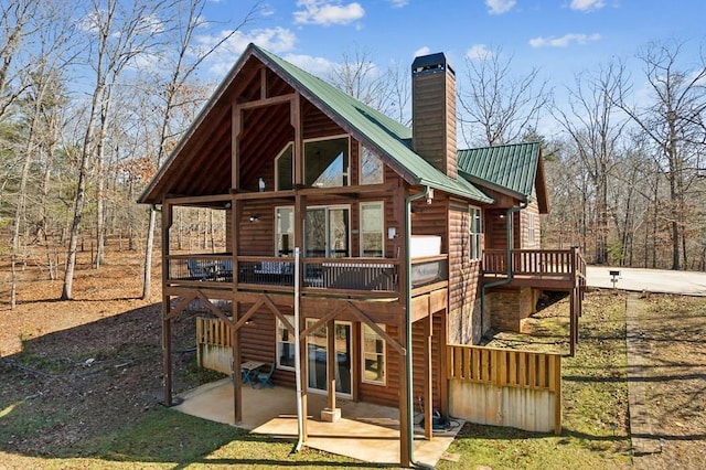 rear view of house featuring a patio area and a wooden deck