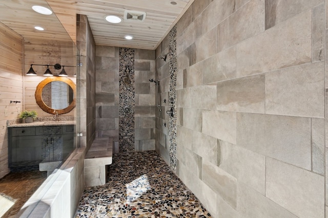 bathroom featuring vanity, tile walls, wooden walls, wood ceiling, and a tile shower