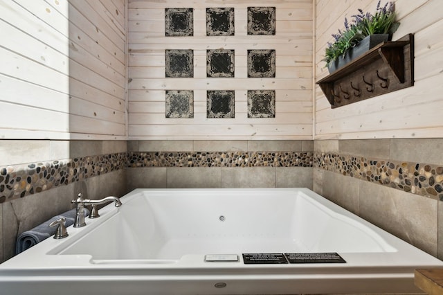 bathroom with a tub and wooden walls