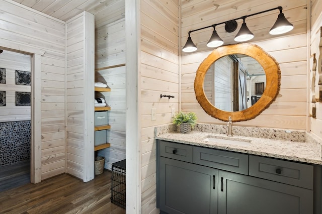 bathroom with vanity, wooden walls, and hardwood / wood-style floors