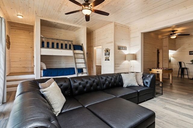 living room with hardwood / wood-style flooring, wooden ceiling, wood walls, and ceiling fan