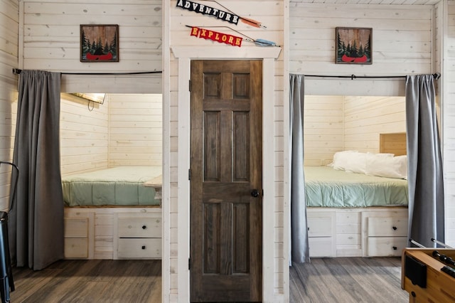 unfurnished bedroom featuring dark hardwood / wood-style flooring and wooden walls