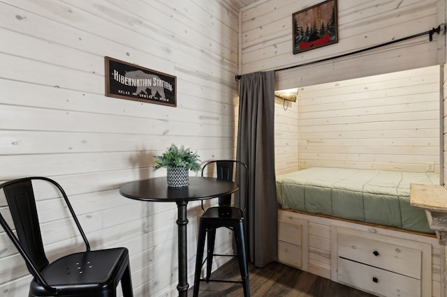 dining area with dark hardwood / wood-style flooring and wooden walls