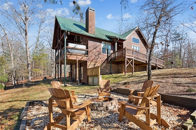 rear view of property featuring a deck and an outdoor fire pit