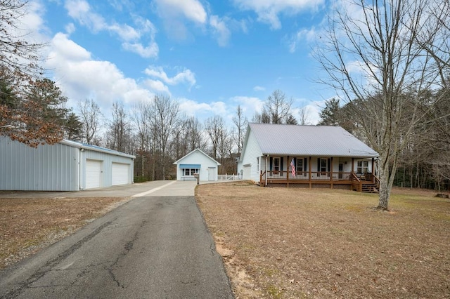 view of front of home featuring a garage, an outdoor structure, a front lawn, and covered porch