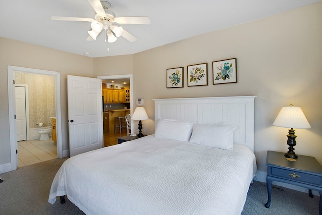 carpeted bedroom with a ceiling fan, baseboards, and connected bathroom