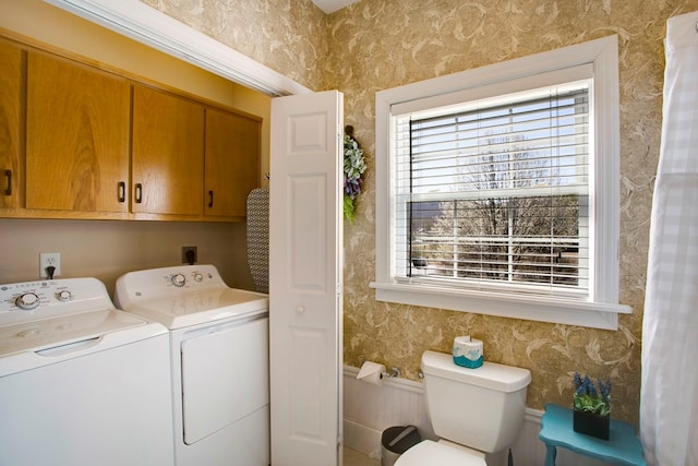 clothes washing area featuring cabinet space, independent washer and dryer, and wallpapered walls