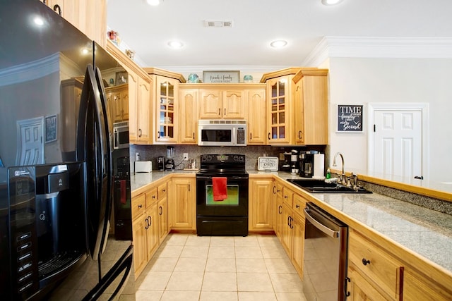 kitchen featuring black appliances, a sink, backsplash, light tile patterned flooring, and tile counters