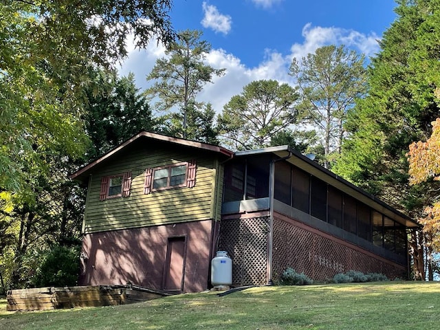 view of home's exterior with a lawn, a sunroom, and a garage