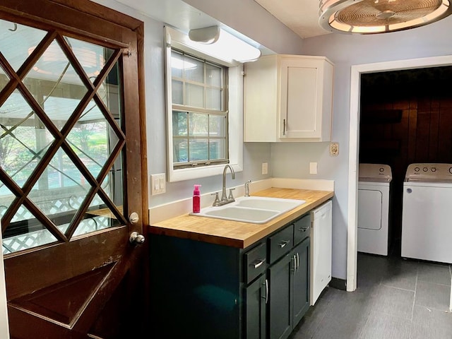 laundry room with separate washer and dryer, dark tile patterned flooring, and sink