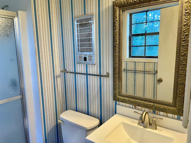 bathroom featuring heating unit, vanity, and toilet