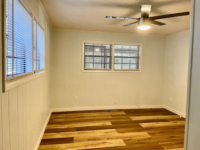 unfurnished room with wood-type flooring, ceiling fan, and a wealth of natural light