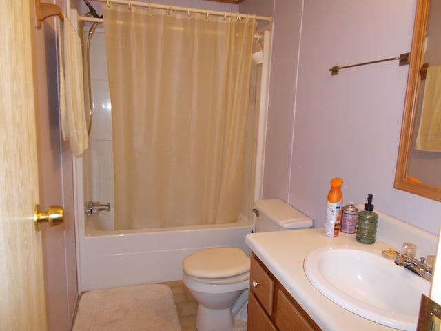 full bathroom with shower / bath combo with shower curtain, toilet, and vanity