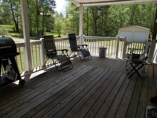 wooden terrace with area for grilling and an outbuilding