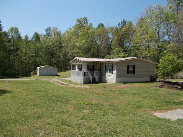 manufactured / mobile home with a porch, stairway, an outbuilding, a garage, and a front yard
