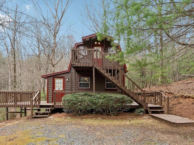 rear view of property featuring stairway and a deck