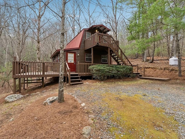 back of house with a deck, metal roof, and stairs