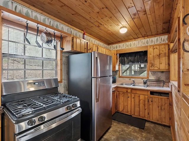 kitchen with appliances with stainless steel finishes, a sink, light countertops, stone finish flooring, and wooden ceiling