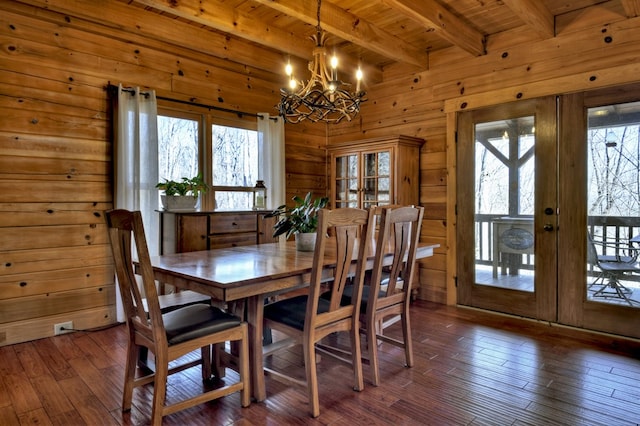 dining space with wooden walls, dark wood-style flooring, french doors, wooden ceiling, and a notable chandelier