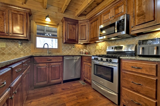 kitchen featuring dark wood finished floors, a sink, wood ceiling, appliances with stainless steel finishes, and beamed ceiling