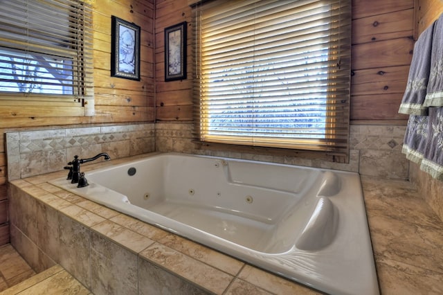 bathroom featuring wood walls and a jetted tub