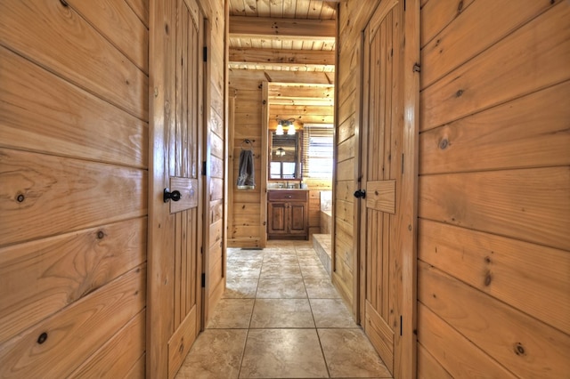 hall with wooden walls and light tile patterned floors