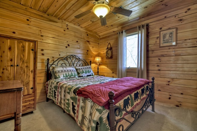 carpeted bedroom featuring wooden walls, wood ceiling, and ceiling fan