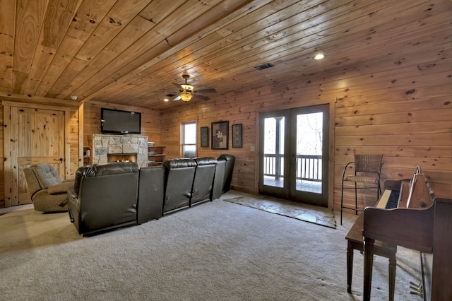 carpeted living room with visible vents, a fireplace, ceiling fan, french doors, and wooden ceiling