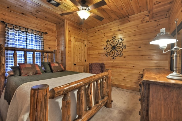 carpeted bedroom with wooden walls, wooden ceiling, and a ceiling fan