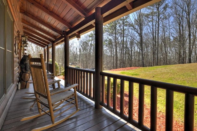 wooden deck with a lawn and covered porch