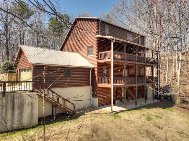 back of property with stairs, a patio, a yard, and a garage