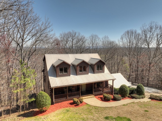 log cabin featuring log siding, covered porch, metal roof, and a front lawn