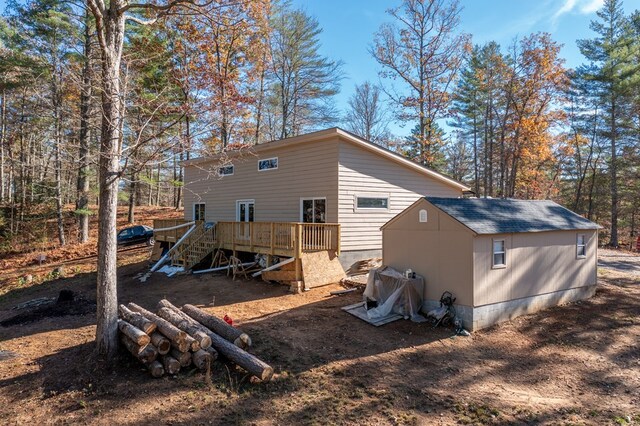 rear view of house featuring an outdoor structure and a wooden deck