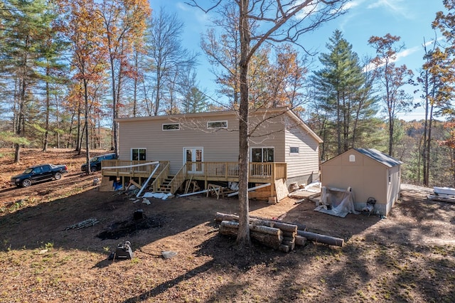 rear view of property featuring a shed and a wooden deck