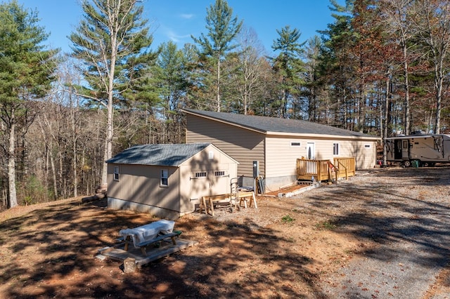 rear view of property featuring an outbuilding