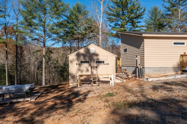 rear view of property featuring a storage unit